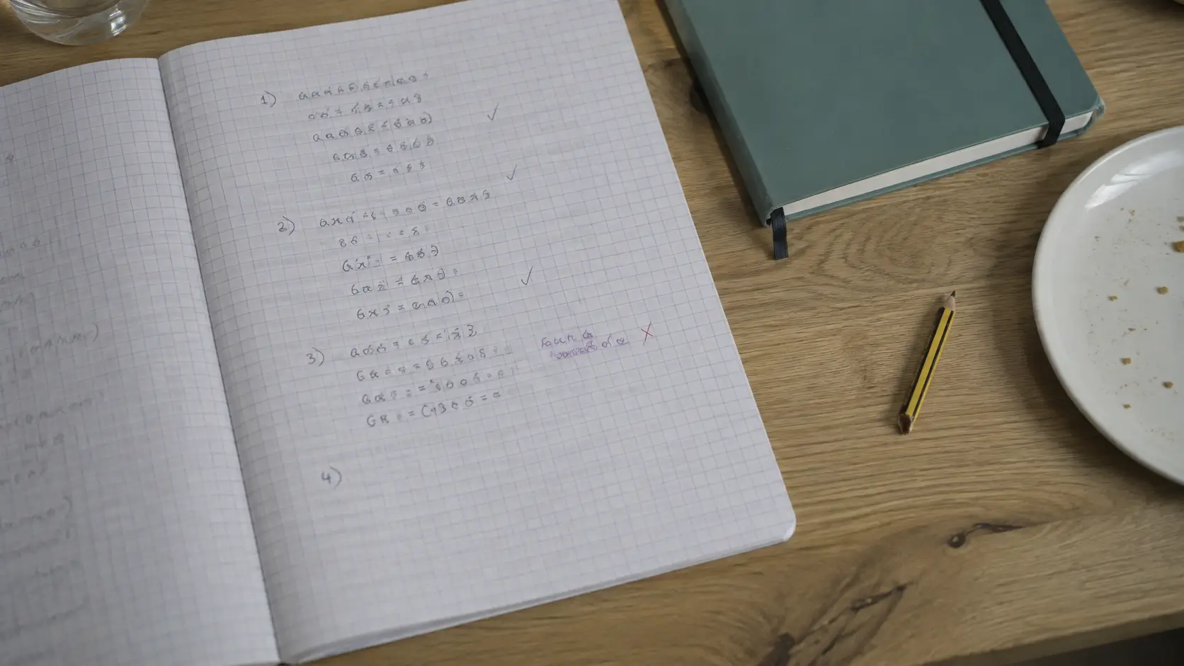 A Year 9 exercise book open at a page of algebra with a school planner beside it on a kitchen table